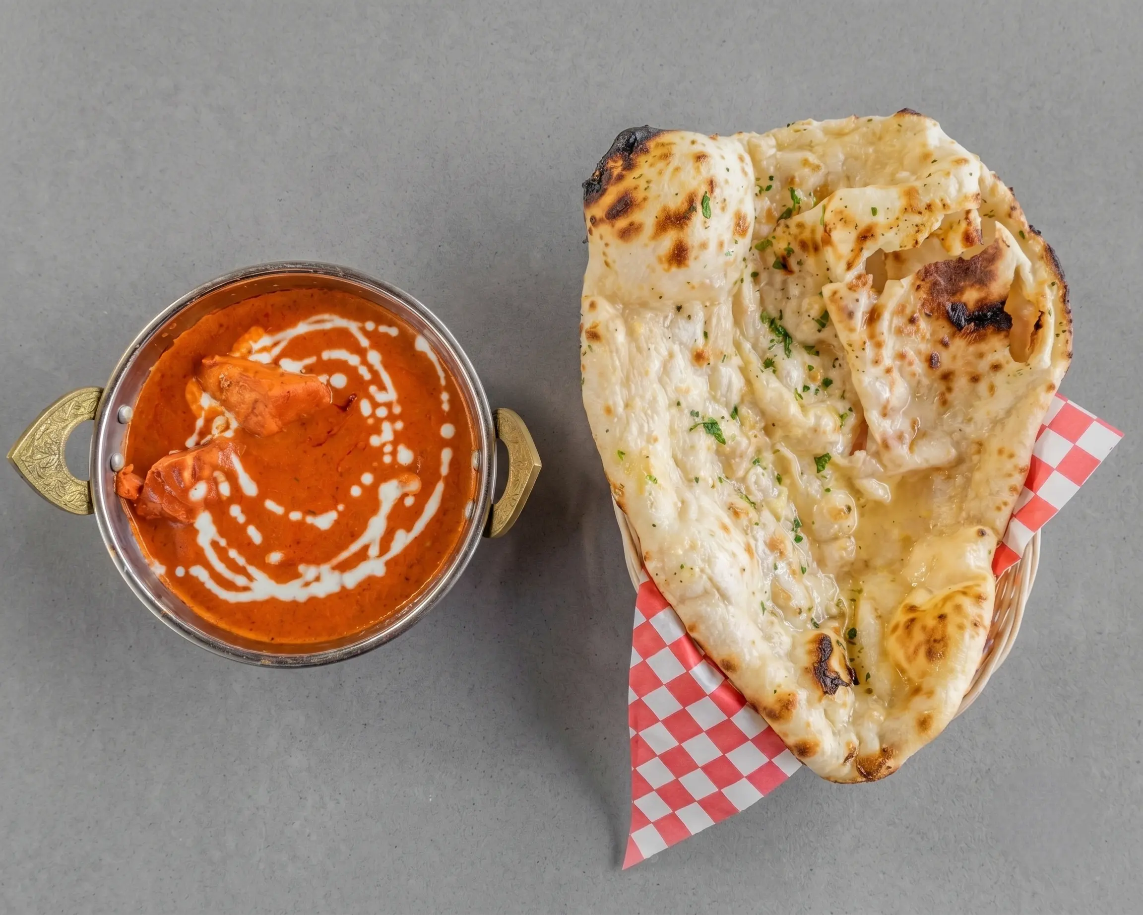 Butter chicken curry served with garlic naan at Haandi Indian Cuisine Calgary